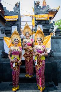 three girls standing on steps in front of a building at Sunset Garden Nusa Lembongan in Nusa Lembongan