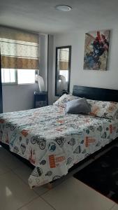1 dormitorio con cama con edredón en RentafrankitoS Ibagué TOP, en Ibagué