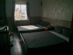 Duas camas num quarto com uma janela em Tuệ Tĩnh Tower 21 em Nha Trang
