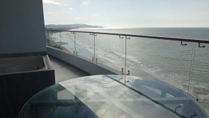 una mesa de cristal en un balcón con vistas al océano en Grand Diamond Beach Tonsupa, en Tonsupa