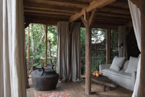 a living room with a couch and a fireplace at Bambu Indah in Ubud