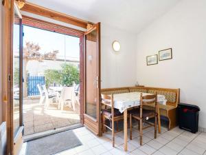 uma sala de jantar com uma mesa e uma porta de vidro deslizante em Villa Narbonne, 3 pièces, 6 personnes - FR-1-409-257 em Narbona