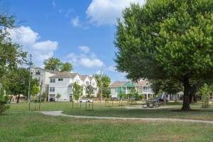 a park with a tree and a playground at Stylish 3 Story Townhouse near East Downtown in Houston