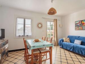 a living room with a table and a blue couch at Appartement au calme à 300 m des plages, 2 chambres, parking, jardin, Guéthary - FR-1-4-686 in Guéthary
