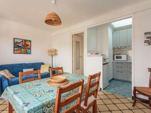 a dining room with a table and a blue couch at Appartement au calme à 300 m des plages, 2 chambres, parking, jardin, Guéthary - FR-1-4-686 in Guéthary
