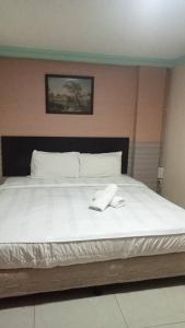 a large white bed with two towels on it at Hotel at Wisma GMT Building Masjid India K L in Kuala Lumpur