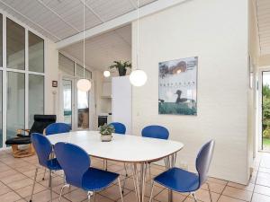 uma sala de jantar com uma mesa branca e cadeiras azuis em 10 person holiday home in Haderslev em Diernæs