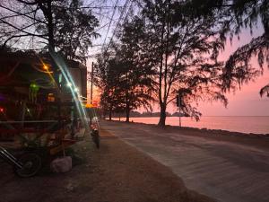 plaża o zachodzie słońca z budynkiem i drzewami w obiekcie Neverland Beach Village Bungalows w mieście Ko Lanta