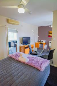 a bedroom with a large bed with a table and chairs at Abbotsleigh Motor Inn in Armidale