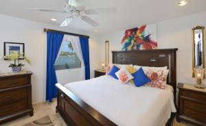 een slaapkamer met een groot bed en blauwe gordijnen bij Coral Beach Club Condo Dawn Beach condo in Upper Princeʼs Quarter