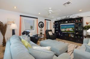 een woonkamer met een blauwe bank en een tv bij Coral Beach Club Condo Dawn Beach condo in Upper Princeʼs Quarter