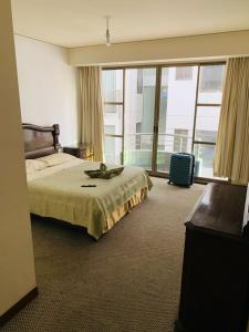 a hotel room with a bed and a large window at Departamento cómodo Cala Cala in Cochabamba