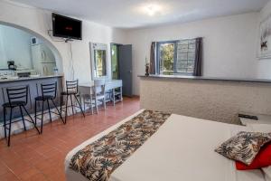 a room with a bed and a kitchen and a bar at Suite/ terraza en la glorieta chapalita in Guadalajara