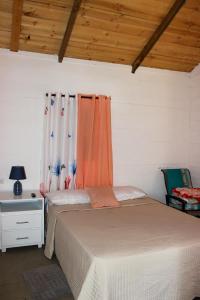 1 dormitorio con 2 camas y una ventana con cortinas en Villa Raynell, en Constanza