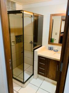 y baño con ducha acristalada y lavamanos. en Departamento cómodo Cala Cala, en Cochabamba
