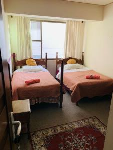 1 dormitorio con 2 camas y ventana en Departamento cómodo Cala Cala, en Cochabamba