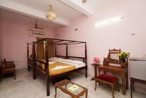 a bedroom with a bed and a table and a desk at Hotel Soorya Inn in Puducherry