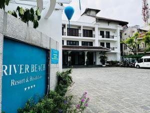 ein Schild für das Resort und die Residenz am Fluss Beelitz in der Unterkunft River Beach Resort & Residences in Hoi An