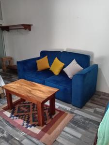 ein blaues Sofa mit Kissen und einem Couchtisch aus Holz in der Unterkunft El Puente in El Paredón Buena Vista