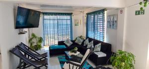 - un salon avec un canapé, des chaises et une télévision dans l'établissement FRESH BEACH HOUSE, à San Andrés