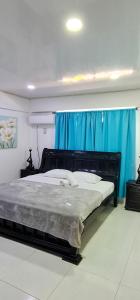1 dormitorio con 1 cama grande y cortina azul en FRESH BEACH HOUSE, en San Andrés