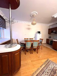 cocina y comedor con mesa y sillas en 241 Рядом с Байтереком и красивым видом на город с 3 кроватями и 2 диванами для 1-9 чел, en Astana