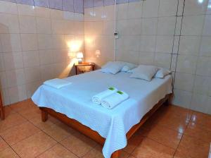 1 dormitorio con 1 cama con 2 toallas en Hostel del Pacífico, en Puntarenas