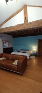 ein Wohnzimmer mit einem Sofa und einem Bett in der Unterkunft Maison l'âne vert in Lay
