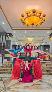 a group of women posing for a picture under a chandelier at Dat Anh Hotel in Hue