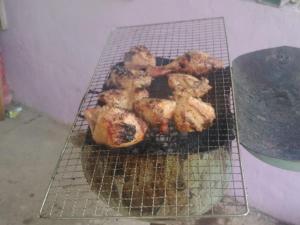 a rack of chicken cooking on a grill at AV HOMESTAY in Kuantan