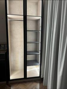 einem leeren Kühlschrank mit Tür neben einem Vorhang in der Unterkunft شقة فاخرة بدخول ذاتي in Riad
