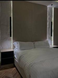 1 Schlafzimmer mit einem weißen Bett und 2 Fenstern in der Unterkunft شقة فاخرة بدخول ذاتي in Riad