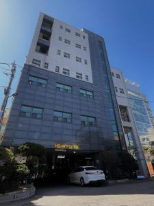 un coche blanco estacionado frente a un edificio en Ho Home Tel, en Seúl