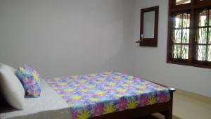 a bed with a colorful blanket on it in a room at Lion's Girl Nature Bungalow in Digana +16 photos