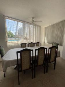 a dining room with a table and chairs with a table and a window at Tonsupa Beach House in Tonsupa