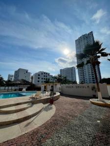 een resort met een zwembad en een palmboom en gebouwen bij Tonsupa Beach House in Tonsupa