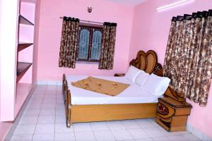 1 dormitorio con 1 cama en una habitación rosa en Subiksha Cottage, en Yercaud