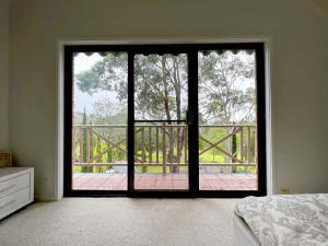 1 dormitorio con una gran puerta de cristal que da a un balcón en Mount Hunter Manor, en Mount Hunter