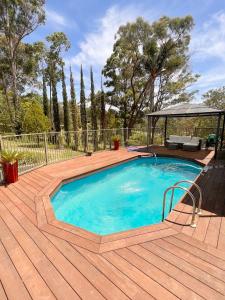 a swimming pool on a wooden deck with a gazebo at Mount Hunter Manor in Mount Hunter