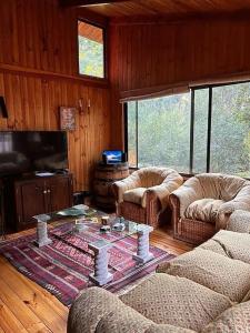 Sala de estar con 2 sofás y mesa de centro en Bosque Mágico Oasis La Campana Hijuelas, en Ocoa