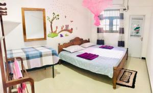 sypialnia z łóżkiem i lustrem w obiekcie Family Villa Mirissa w mieście Mirissa