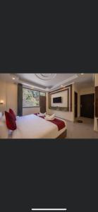 um quarto amplo com 2 camas e uma televisão de ecrã plano em HOTEL RAJMAHAL GREEN em Bhiwadi