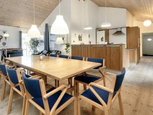 a dining room with a wooden table and chairs at Holiday home Rødby LVI in Rødby