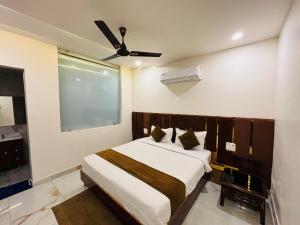 a bedroom with a bed and a ceiling fan at Hotel Fusion in Kurukshetra