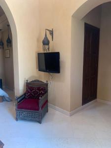een tv op de hoek van een kamer met een stoel bij Nubia Gouna in Hurghada