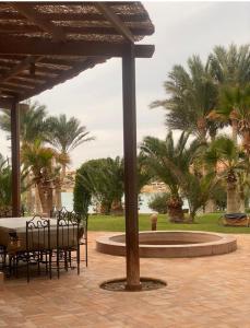 a table and chairs under a pavilion with palm trees at Nubia Gouna in Hurghada