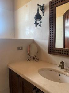 uma casa de banho com um lavatório e um espelho em Nubia Gouna em Hurghada