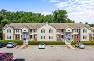 a large apartment building with cars parked in a parking lot at Haven Away From Home Ideal For Long Term Stays in Fayetteville