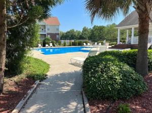a swimming pool with two chairs and a house at Haven Away From Home Ideal For Long Term Stays in Fayetteville