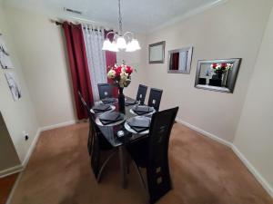 a dining room table with black chairs and flowers on it at Haven Away From Home Ideal For Long Term Stays in Fayetteville